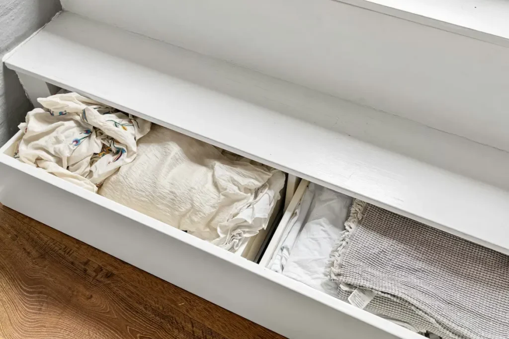 clear labeled under-bed storage bins in a small bedroom maximizing floor space